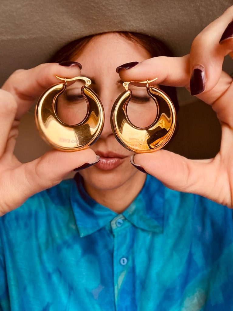 Daniela di Big Yes Creations mostra in primo piano i suoi chunky hoop dorati